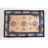 Chinese wool rug, the peach ground with flowers and foliate scroll work within Greek key border,