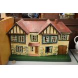 1960's hardboard and plastic dolls house, with a selection of furniture and figures, 39cm x 70cm x