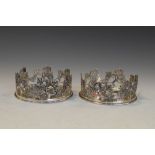 Pair of white metal bottle coasters or decanter stands with pierced fruiting vine decoration,