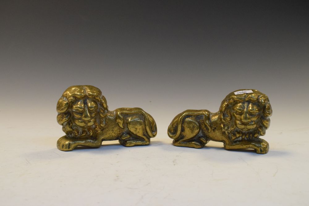 Pair of antique cast brass door stops in the form of recumbent lions, each 12.5cm high