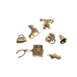 Eight assorted gold and yellow metal charms, 17g gross approx