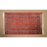 Afghan or Belouch rug, the brick-red field with two rows of twelve guls, 94cm x 171cm