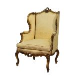 Louis XV-style giltwood wing-back fauteuil or occasional chair, the shaped padded back with