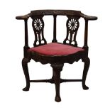 18th Century walnut 'smoker's bow' corner armchair, later carved, the curved top rail with flower