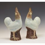 Pair of 20th Century Chinese porcelain figures of cockerels, each standing upon a tree stump base,