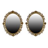Pair of 19th Century giltwood and gesso oval wall mirrors, each having a plain plate with beaded