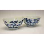 Pair of Chinese porcelain blue and white bowls, each decorated with tall trees in a landscape and
