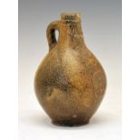 17th Century Continental salt-glazed stoneware Bellarmine jug, of typical bulbous form with