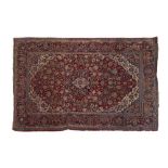 Early 20th Century Middle Eastern (Persian) carpet, the brick-red field with central ogee