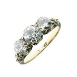 Three stone diamond ring, the old brilliant cuts totalling approximately 1.6 carats, to a carved