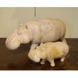 Two carved soap stone figures of hippos, the larger standing 16.5cm high