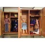 Two vintage Sindy Dolls, within wooden wardrobes having various clothing and accessories, together