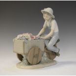Lladro porcelain figure of a flower seller pedalling a wooden cart, 25.5cm high