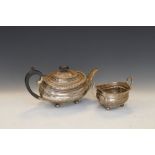 George V silver teapot and two-handled sugar basin, each with gadrooned rim on four ball feet,