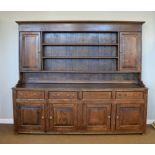 20th Century oak dresser, the base fitted four short drawers over four panelled cupboard drawers