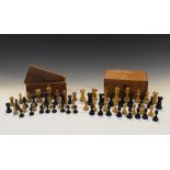 Two early 20th Century carved wooden chess sets, natural and ebony-stained, the kings all 7cm