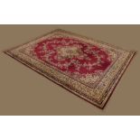 Large machine-made wool rug or carpet, the dark red field with central medallion and allover flowers