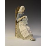 Lladro porcelain figure of a seated female embroiderer in high-backed chair, 27.5cm high