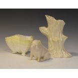 Three items of Irish Belleek porcelain comprising: a seated pig, shell vase and tree stump vase,