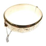 9ct gold snap bangle of hollow design, one half with foliate scroll engraving, 26.5g approx