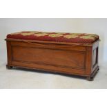 19th Century mahogany ottoman having hinged cover with needlepoint upholstery, raised on bun feet,