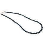 Graduated string of cultured black pearls, the yellow metal clasp stamped 9ct