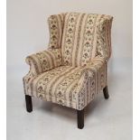 Georgian style wingback armchair raised on mahogany supports having floral striped upholstery