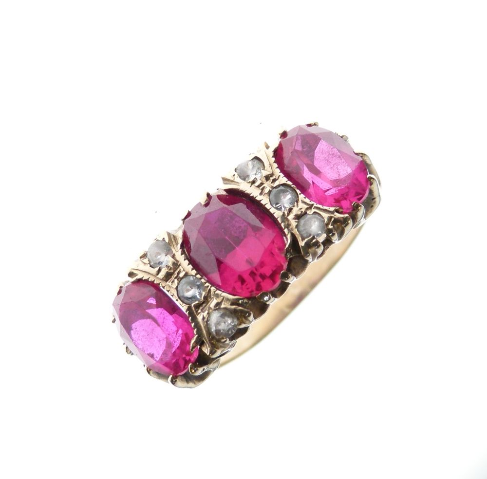 Unmarked yellow metal dress ring set three large oval faceted ruby-coloured stones (synthetic