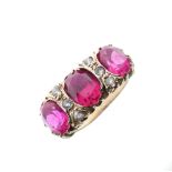 Unmarked yellow metal dress ring set three large oval faceted ruby-coloured stones (synthetic