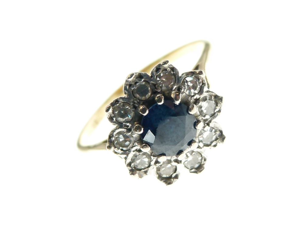 Yellow metal, sapphire and diamond cluster ring set central stone within a border of ten diamonds,