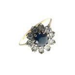 Yellow metal, sapphire and diamond cluster ring set central stone within a border of ten diamonds,