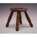 Rustic milking stool, the circular seat on four splayed turned supports, 20cm diameter