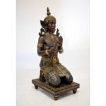 Kneeling resin figure of a South East Asian male on rectangular plinth, 96cm high