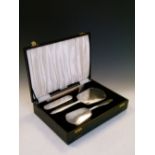 Elizabeth II silver cased dressing table set comprising: hand mirror, hand brush, clothes brush