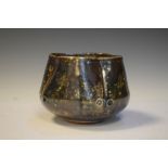 Small pottery vase, painted with swirl motif on a brown ground,