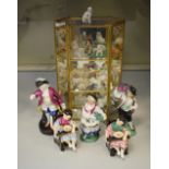 Glazed miniature cabinet containing miniature porcelain figures of dogs and other animals,