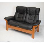 Ekornes Stressless two-seater settee upholstered in black leather on stained beech supports