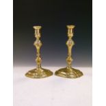 Pair of 18th Century brass candlesticks, each with seamed socket and knopped stem on stepped