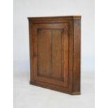 George III oak corner cupboard with panelled door enclosing two shaped shelves, 92cm high