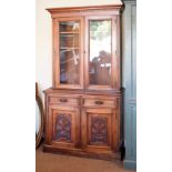 Late 19th/early 20th Century walnut two section bookcase, the upper fitted pair of glazed doors, the