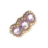 18ct gold dress ring set three amethyst coloured stones within seed pearl border, size R, 4g gross