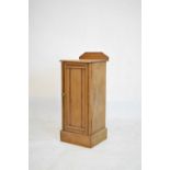 Stripped pine bedside cabinet or night cupboard with reeded door enclosing shelf, 33cm wide x 84cm