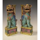 Pair of Oriental green temple lions, seated on yellow and pink mount, 25cm high