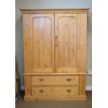 Stripped pine linen press enclosing hanging space over two drawers on plinth base, 134cm wide x