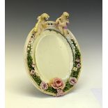 Large German porcelain oval mirror, with cherub and floral design, 30cm x 27cm