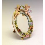 Small German porcelain oval mirror, with cherub and floral design, 17cm x 12cm