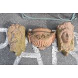 Pair of terracotta wall pockets or rain hoppers modelled as a male and female mask, 45cm high,
