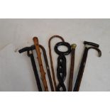Group of walking sticks and canes to include; a silver-mounted example, thornwood example and two