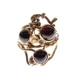 9ct gold dress ring of Modernist design set three red garnet-coloured cabochons, size N, 6.9g