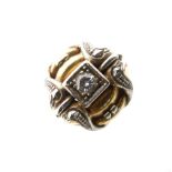 Unusual yellow metal and solitaire diamond dress ring, between white metal scroll shoulders,